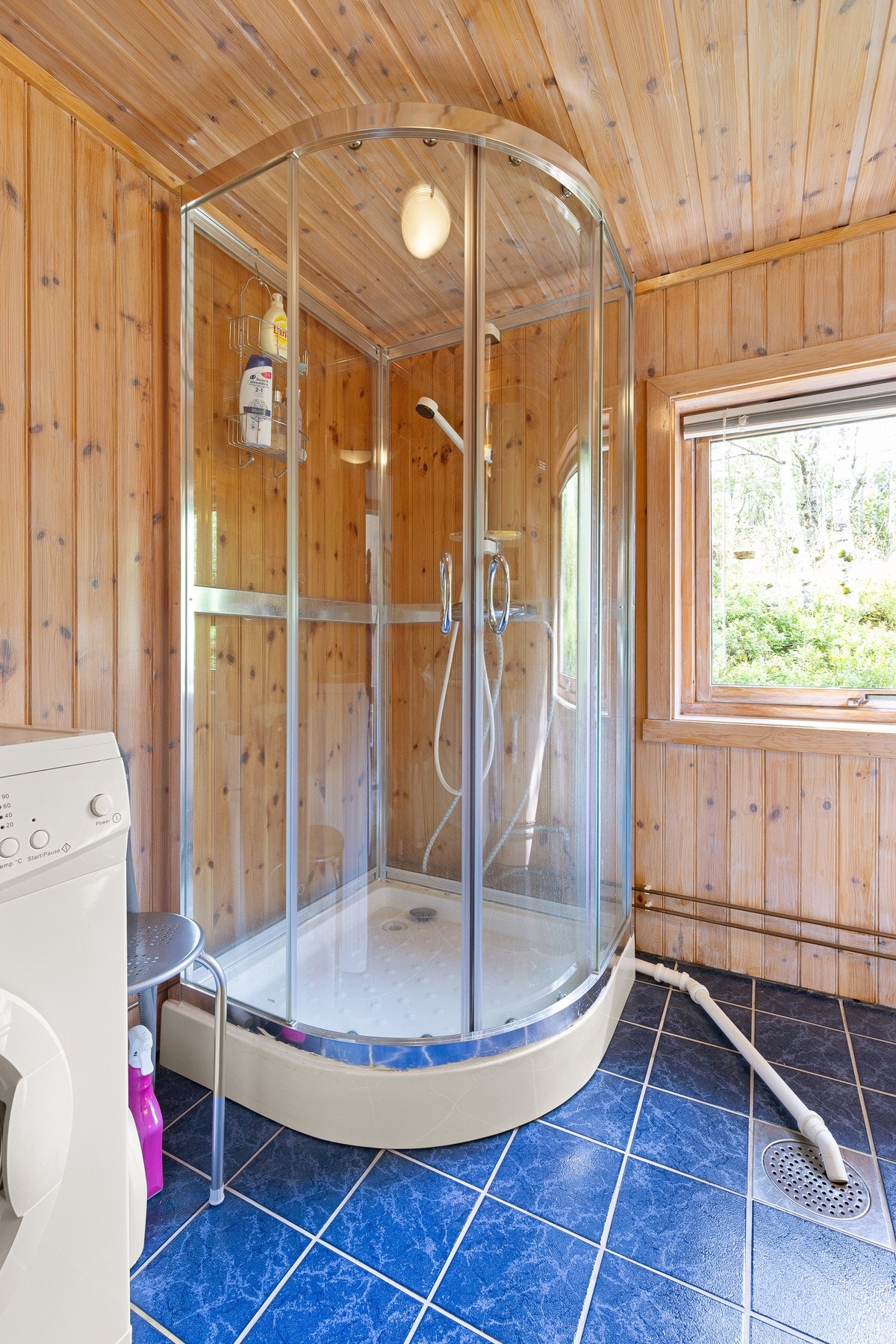 Elektrisk avtrekksvifte i vegg. Innredning med nedfelt servant, gulvmontert toalett, dusjkabinett og opplegg for vaskemaskin. Flislagt gulv med varmekabler og sluk. Galleribilde