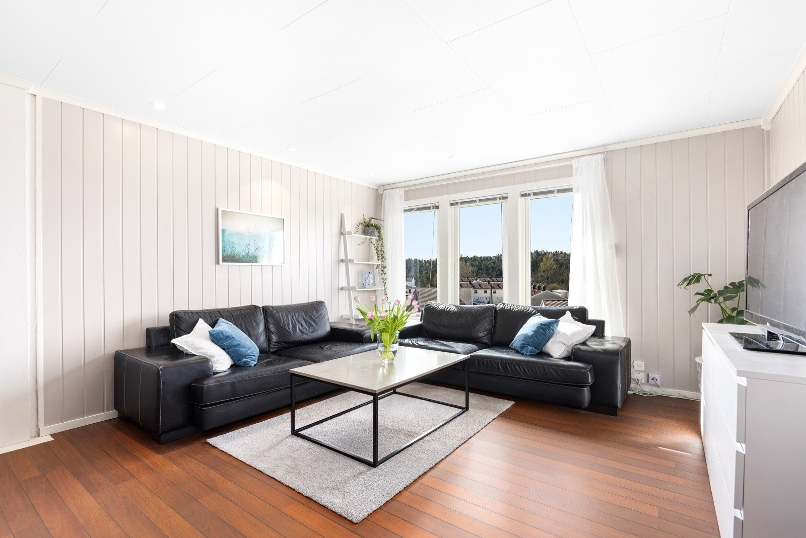Stuen er lys og trivelig, med store vindusflater som slipper inn rikelig med naturlig lys og gir en fin utsikt. Galleribilde
