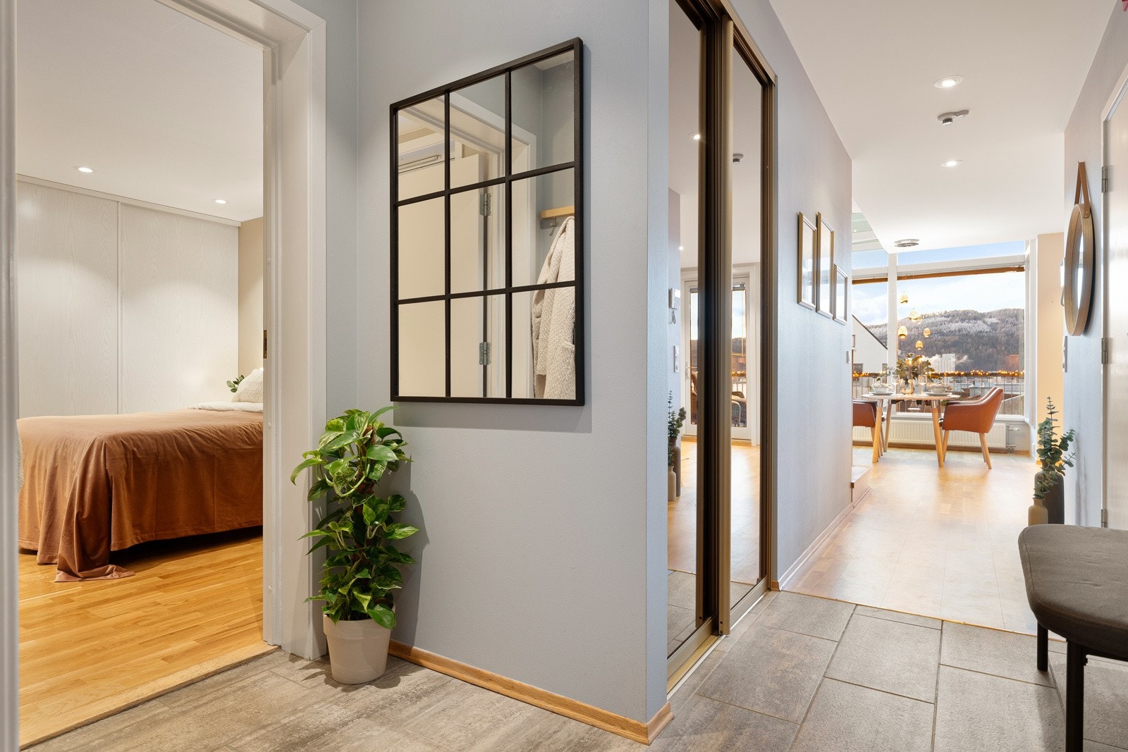 Flislagt entrè/gang med varme i gulv, med god plass til oppbevaring av yttertøy i plassbygd skyvedørsgarderobe. Galleribilde