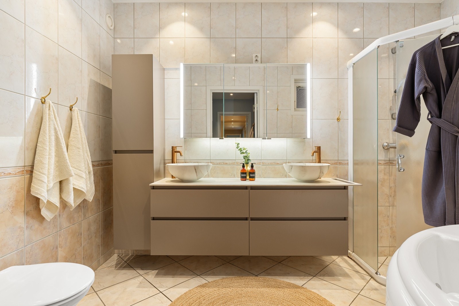 Baderommet er stilrent med dobbeltservant, vegghengt toalett, dusjhjørne og boblebadekar. Galleribilde