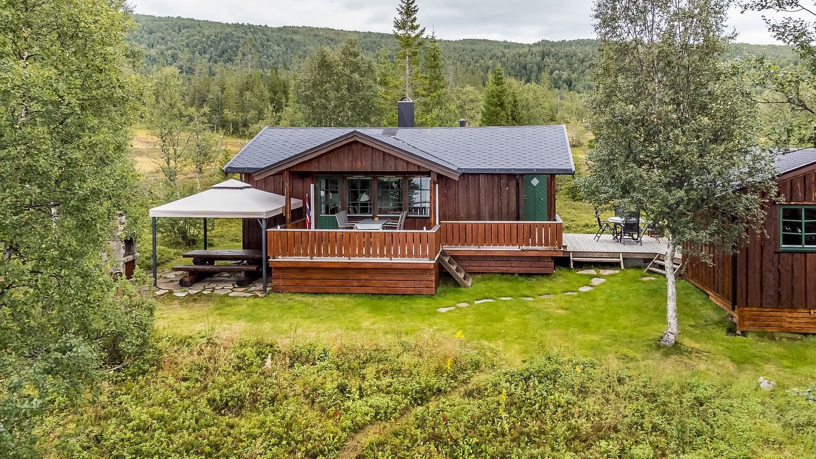 Grillplass etablert rett ved den romslige terrassen, der det i tillegg er steinbelagt med tilhørende robust benk. Galleribilde
