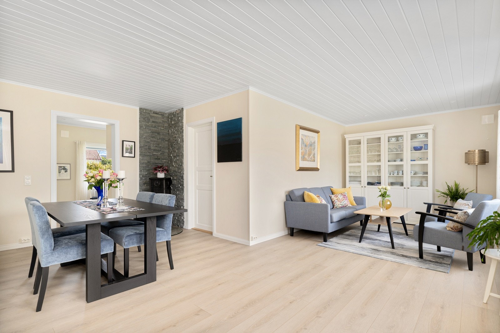 I hjørnet av stuen er det en peisovn, og det er god plass til både tv-lounge og stort spisebord. Galleribilde