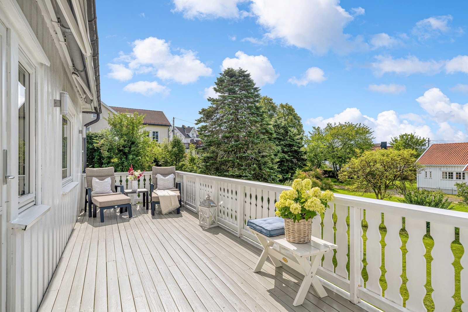 Terrassen har dekke av terrassebord, hvitmalt rekkverk , utebelysning og en elektrisk markise. Galleribilde