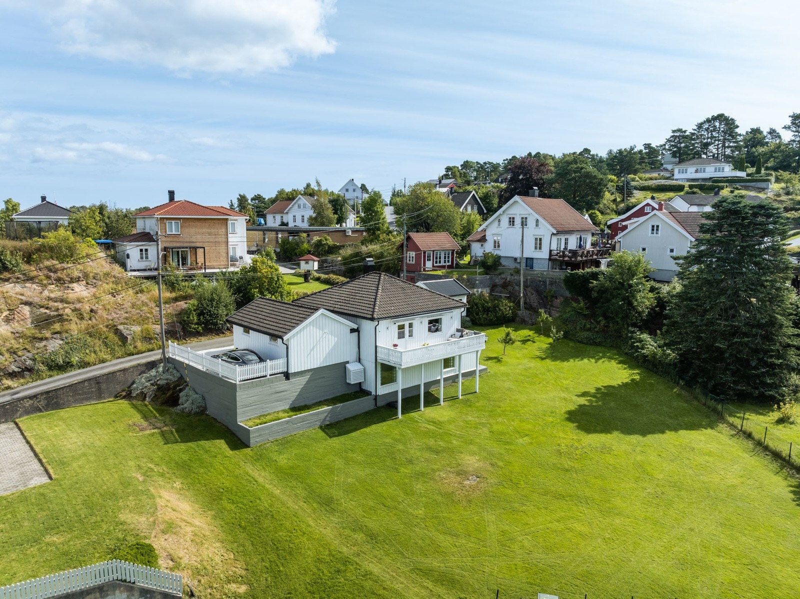 Området er grønt og frodig preget av hvitmalte trehus, og ligger kun et par minutters spasertur fra sjøen. Galleribilde