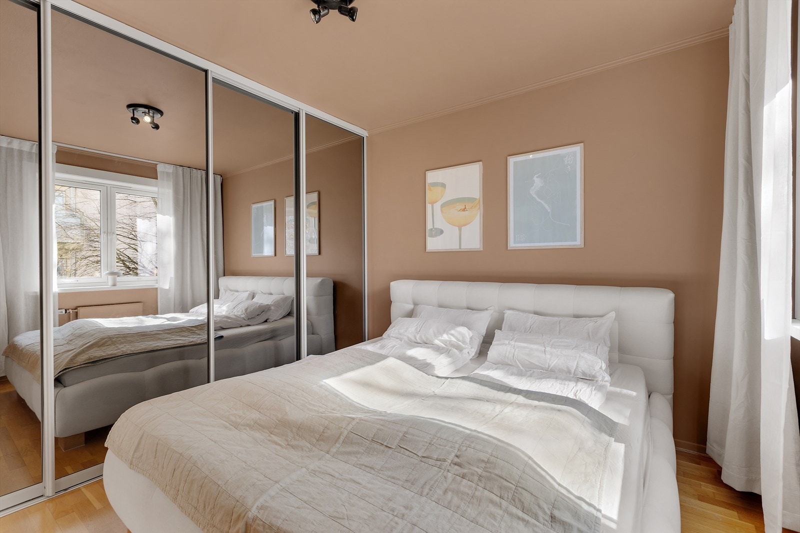 Lyst og romslig hovedsoverom med stor skyvedørsgarderobe Galleribilde