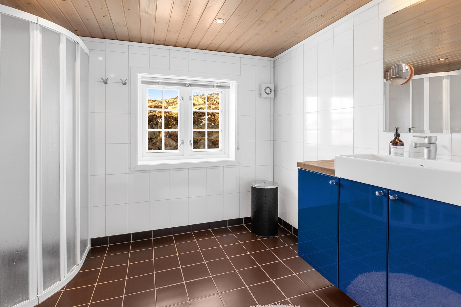 Badet har fliser på gulv og baderomsplater på vegg Galleribilde