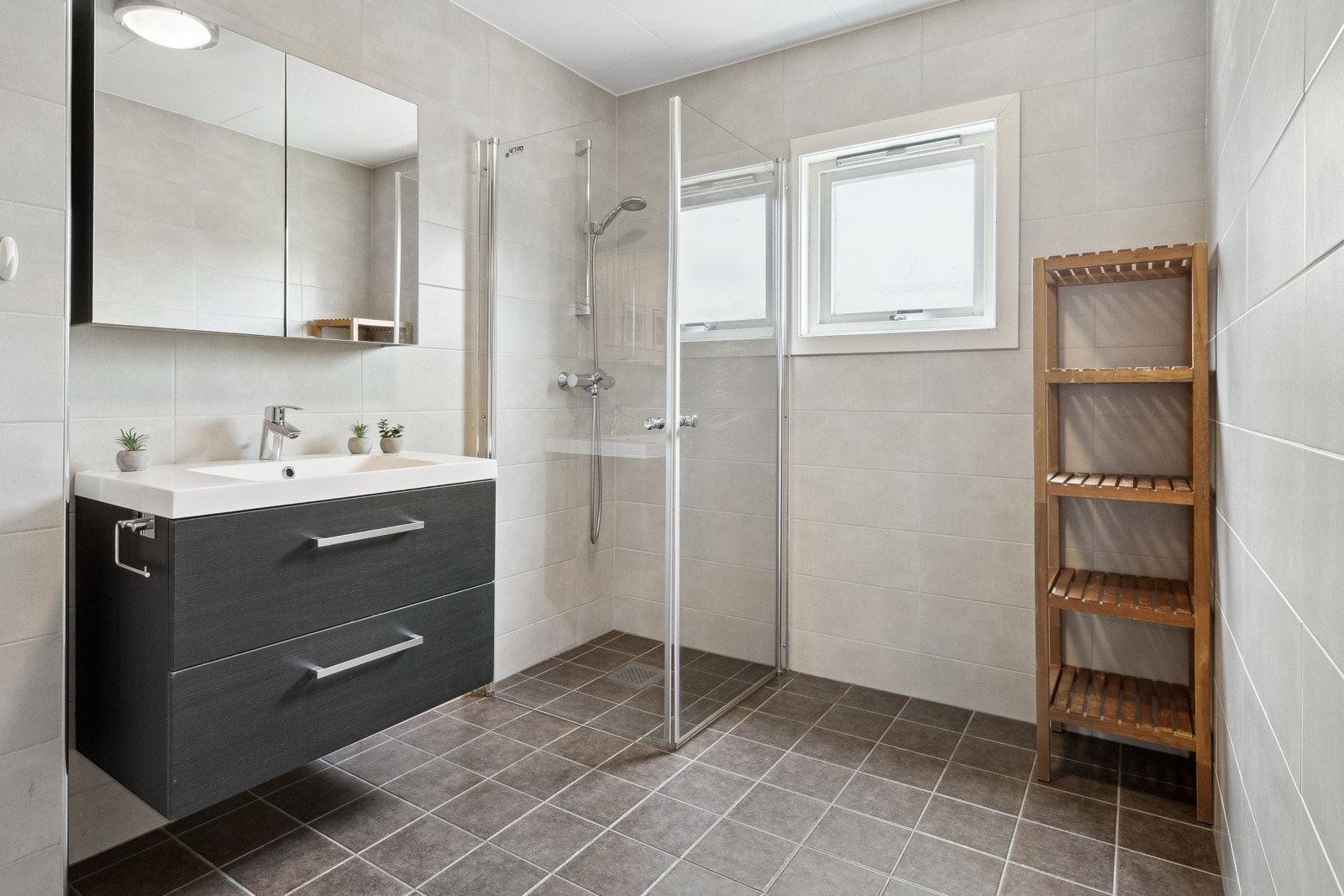 Det er vegghengt servant med overskap for praktisk oppbevaring. Galleribilde