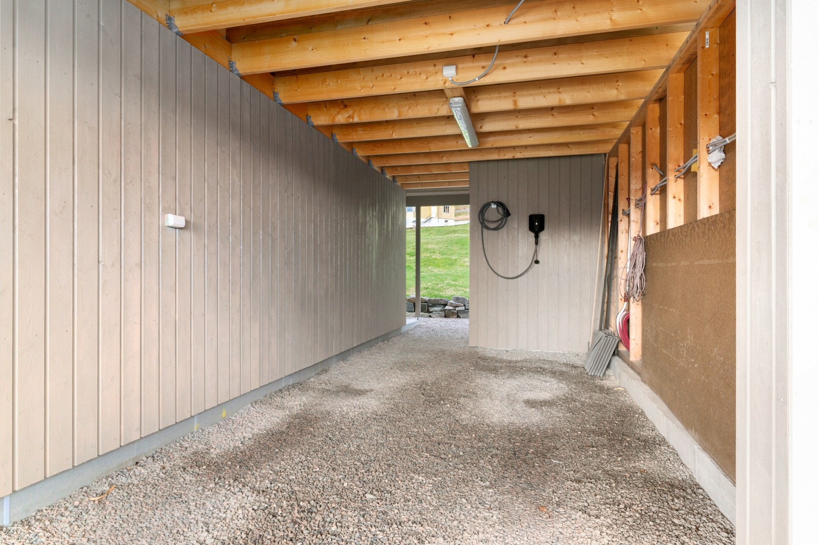 Bilen parkeres enkelt i carporten, hvor det også er montert elbil-lader. Galleribilde