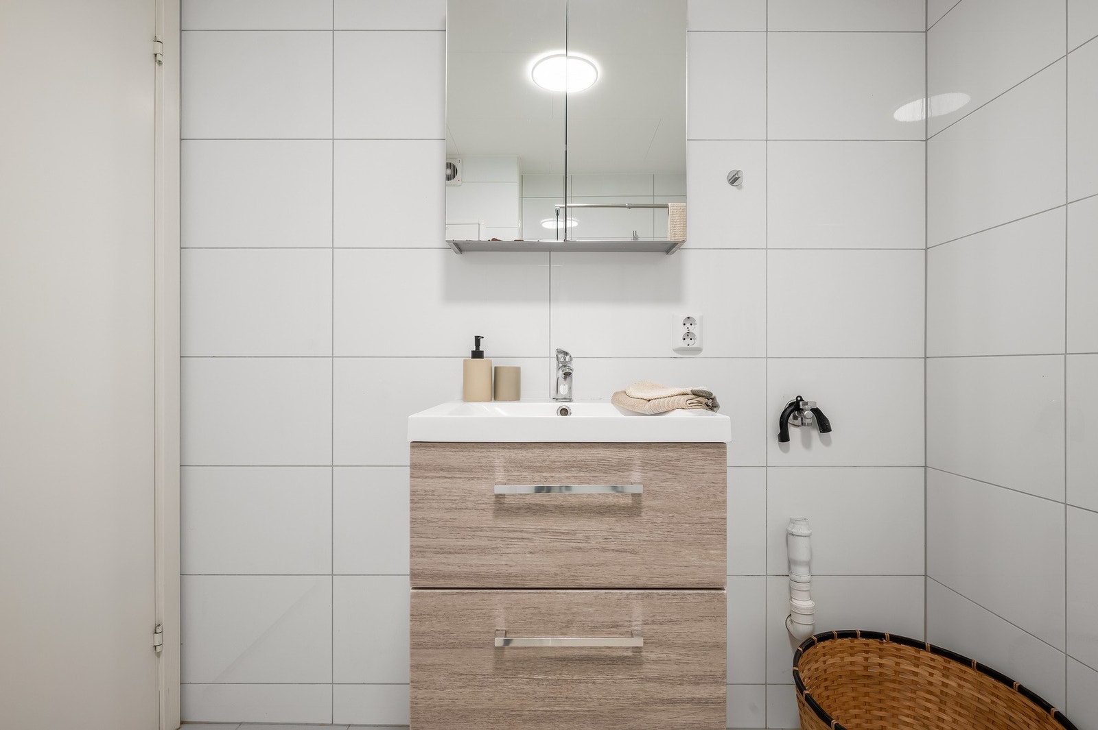Baderomsinnredningen består av vegghengt toalett, dusj med glassnisje, servant med møblement, speil og belysning, samt opplegg for vaskemaskin. Galleribilde