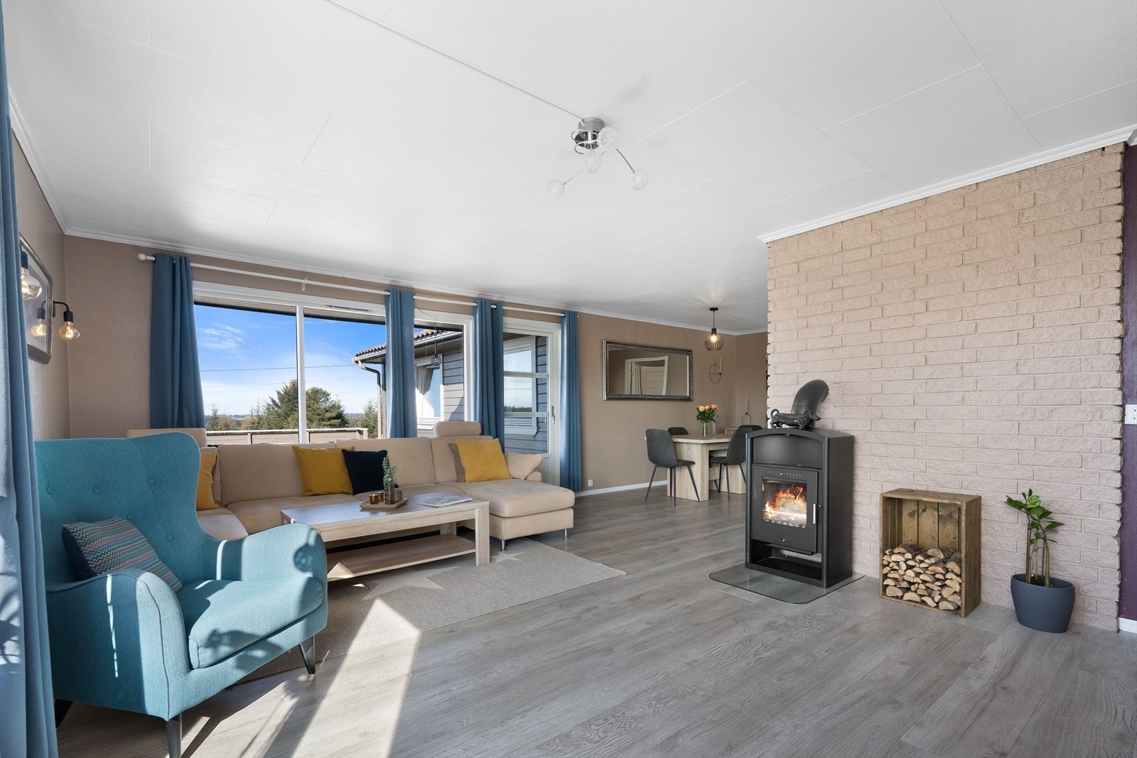 En lys og luftig stue, med store vinduer og utgang til terrasse. Galleribilde