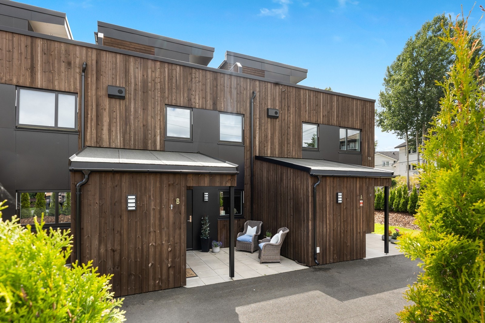 Ved det innbydende inngangspartiet er det en hellelagt uteplass, med plass til koselige entré- møbler Galleribilde