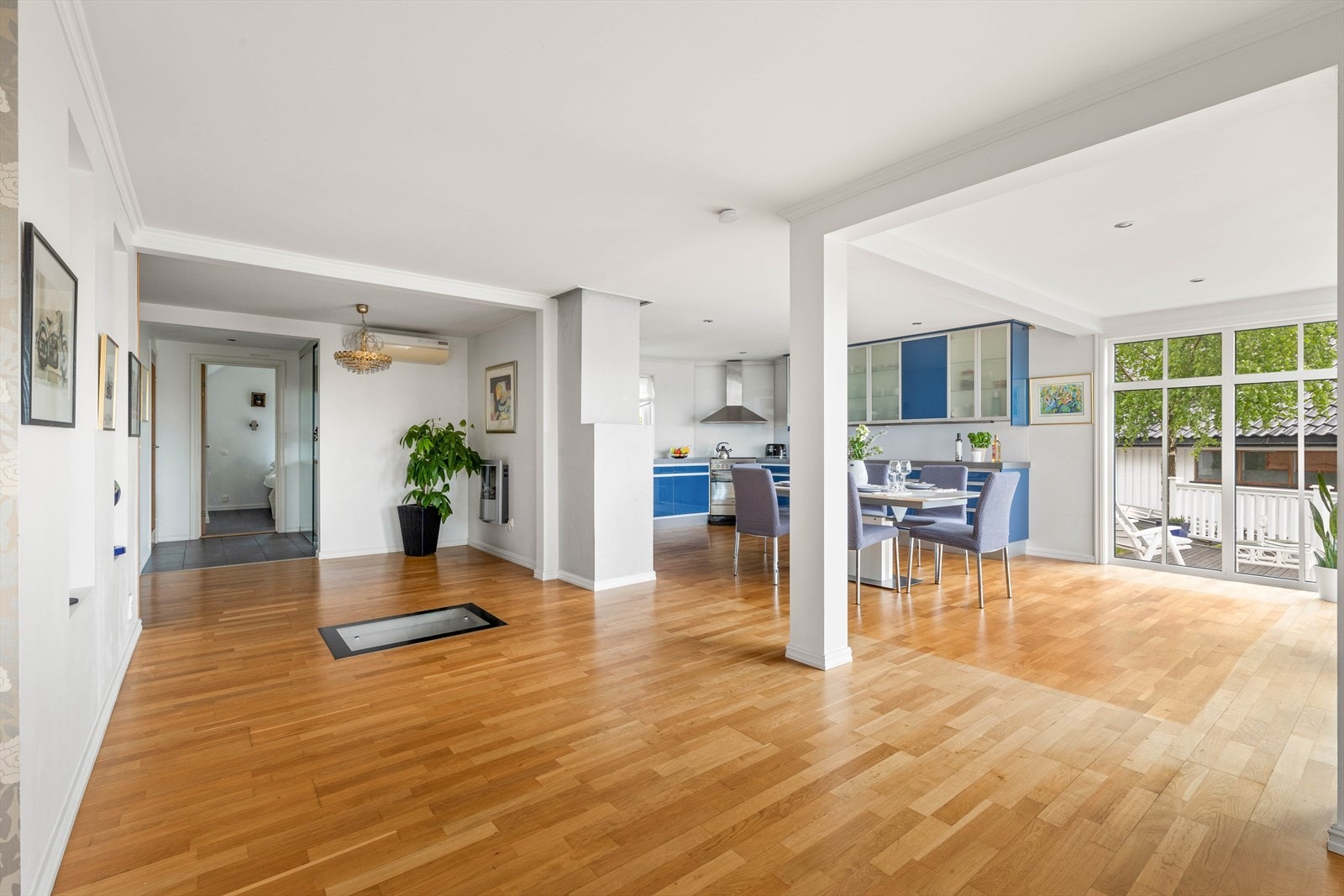 Stuen og kjøkkenet er i åpen løsning. Et lyst og luftig rom med flere møbleringsmuligheter. Rommet bades i dagslys fra sprossevinduer på fire sider, og har skyvedører ut til en stor terrasse og videre til en frodig hage. Galleribilde