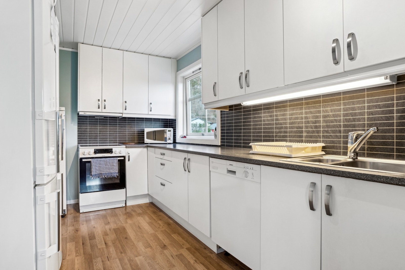 Kjøkkeninnredning fra 2010 med glatte fronter og laminert benkeplate. Galleribilde