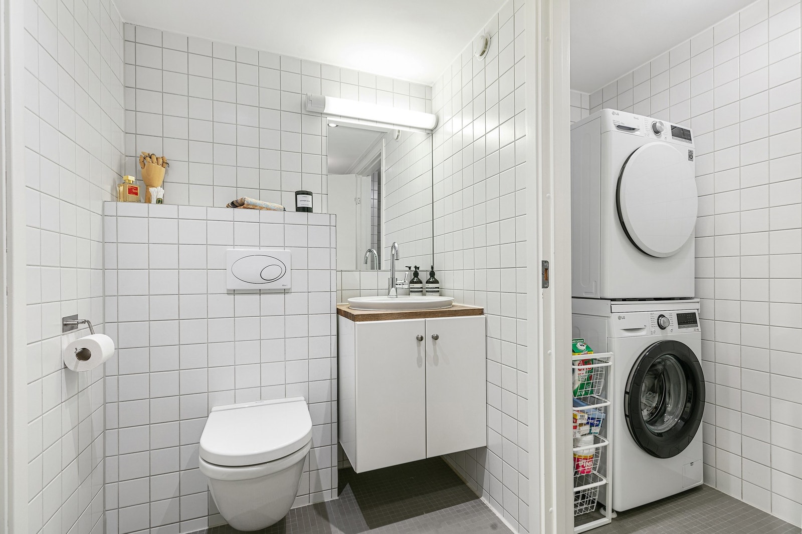 Det flislagte badet har en praktisk deling mot vaskerom med opplegg for vaskemaskin/tørketrommel. Galleribilde