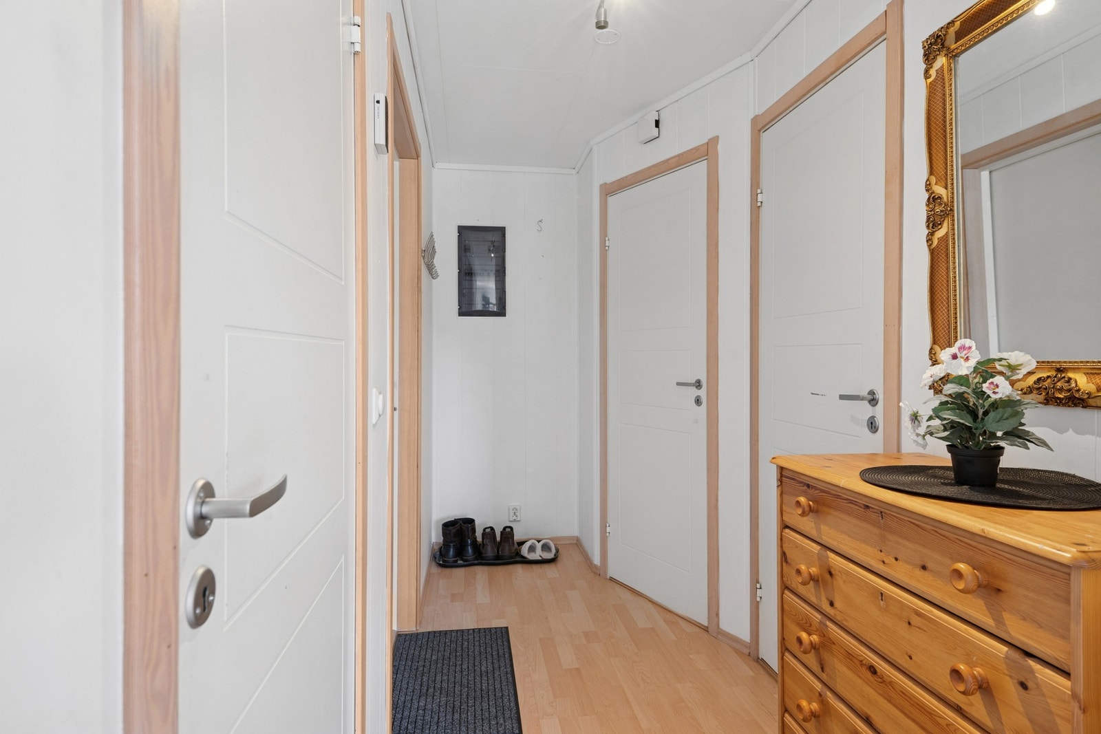 Koselig entré med plass til sko og yttertøy. Laminat på gulv og malte vegger. Galleribilde