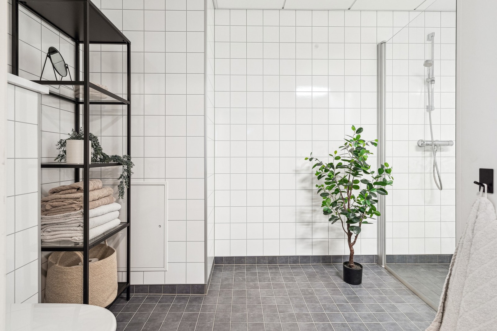 Badet har flislagt gulv og våtromsplater på vegg. Galleribilde