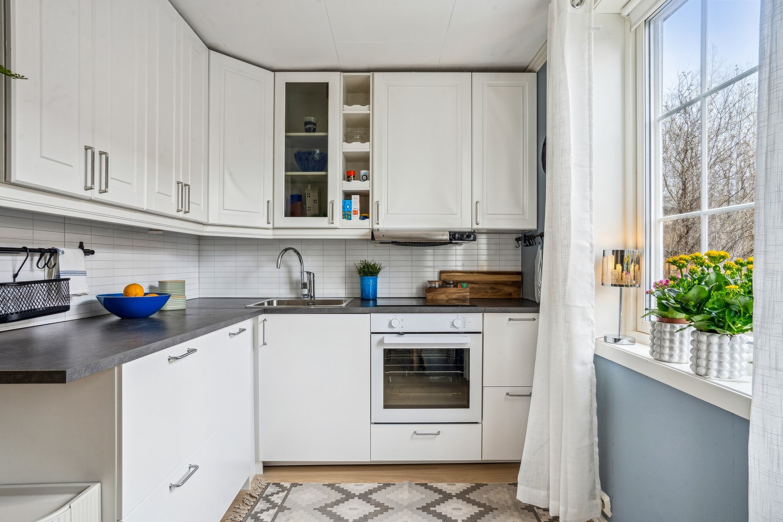 Lys innredning med glatte fronter og integrert stekeovn, platetopp og oppvaskmaskin. Galleribilde