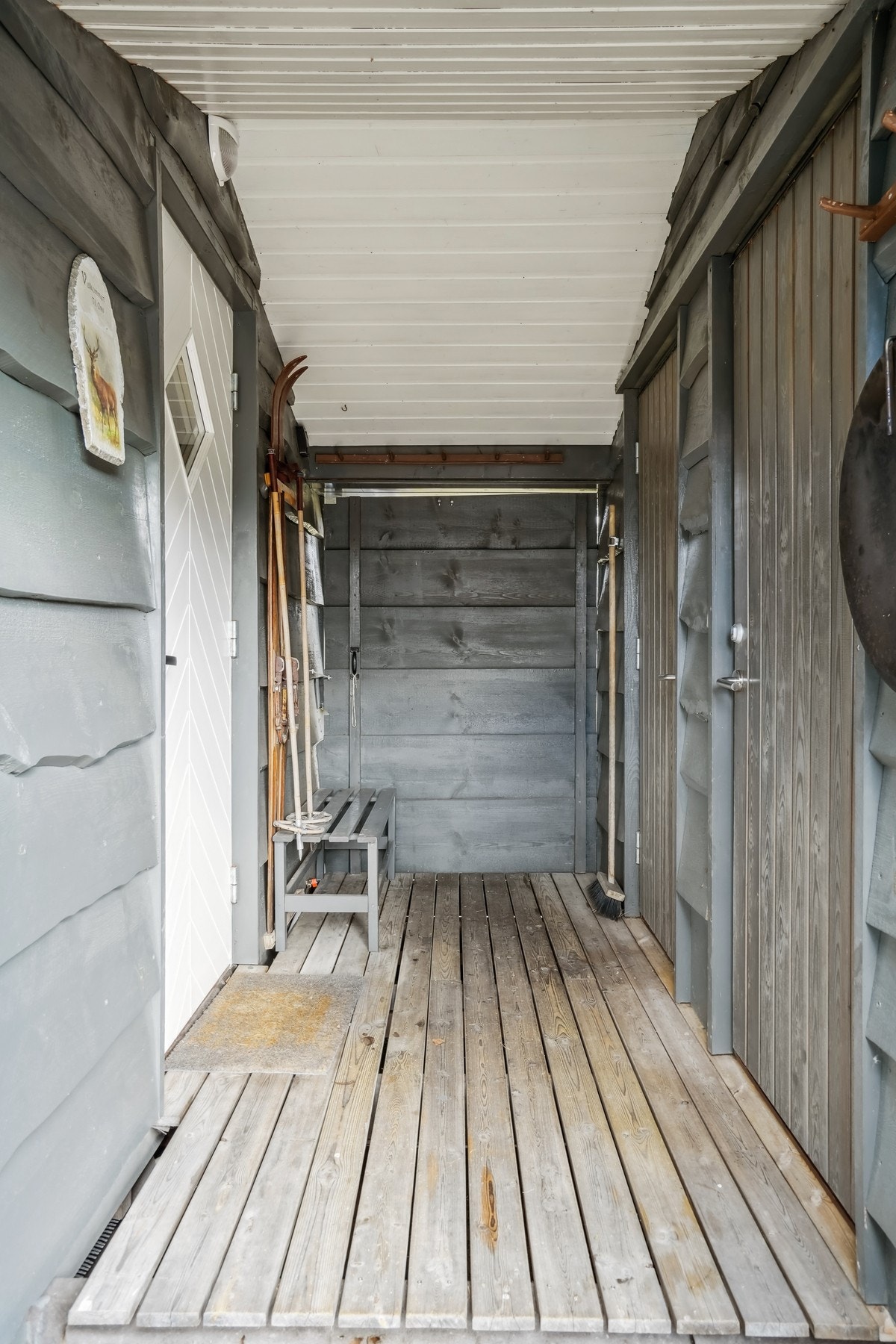 Inngangspartiet er overbygd med svalgang. Til venstre er inn til hytten og til høyre er dør til toalettrom og til bod/grovkjøkken. Galleribilde