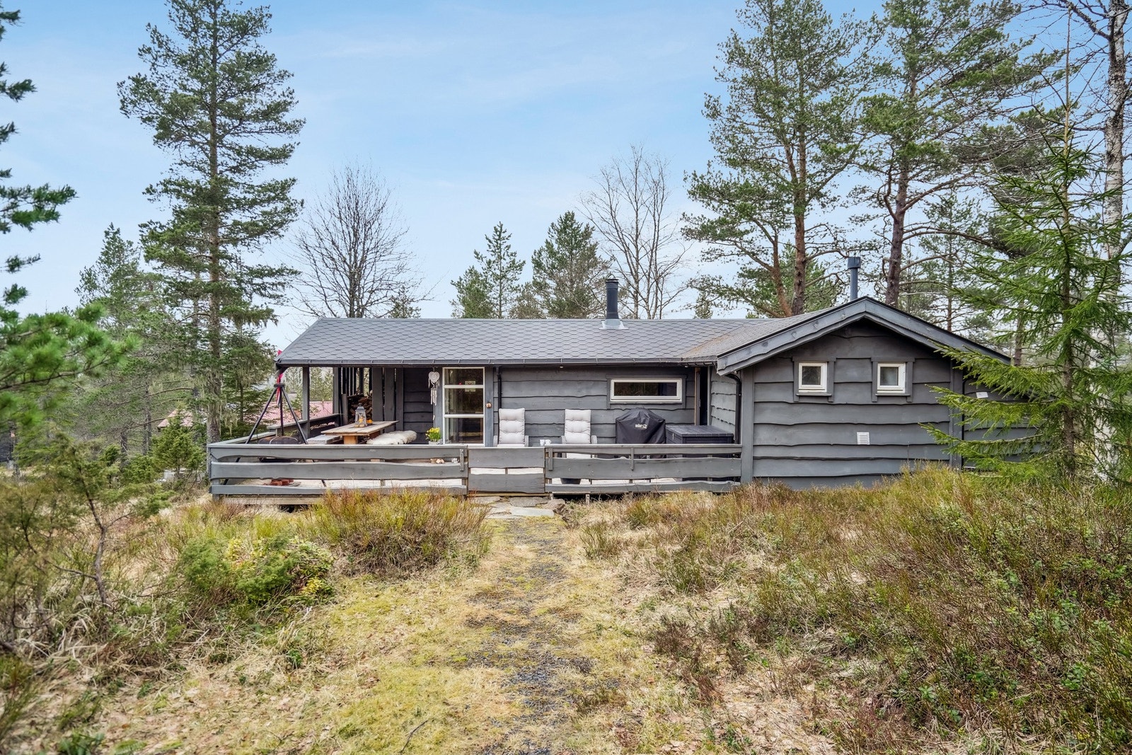 Fasade mot sør. Hytten ligger svært fin i terrenget, har villmarkspanel og vegetasjonen rundt gir fin ramme rundt. Galleribilde