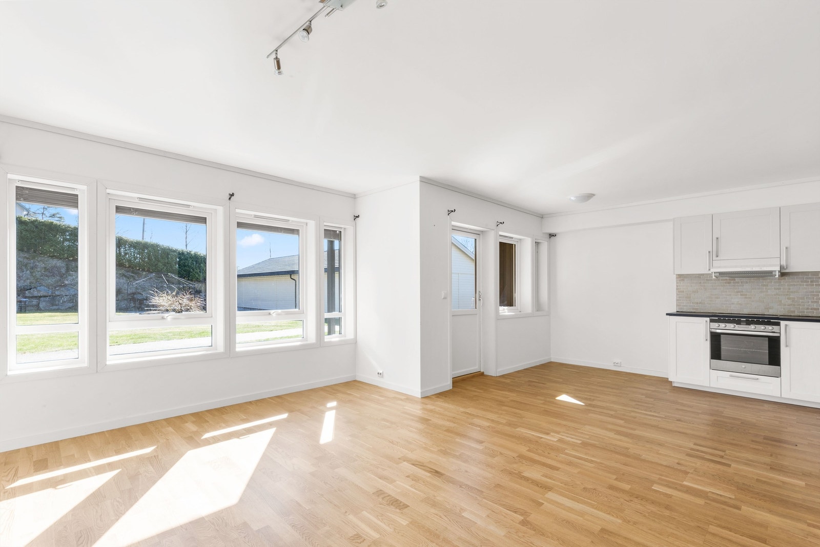 Store vindusflater slipper inn rikelig med naturlig lys og bidrar til et lyst, luftig og trivelig miljø i stuen Galleribilde