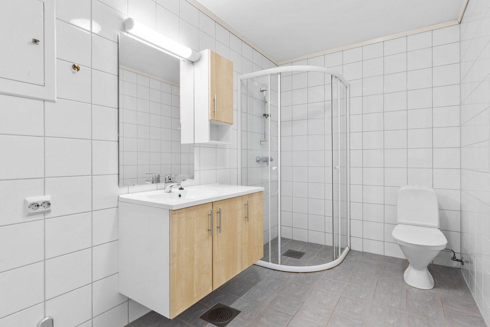 Ryddig og praktisk baderom med dusjkabinett og frittstående toalett. Enkel innredning som gir god utnyttelse av plassen.( Må fikses ) Galleribilde