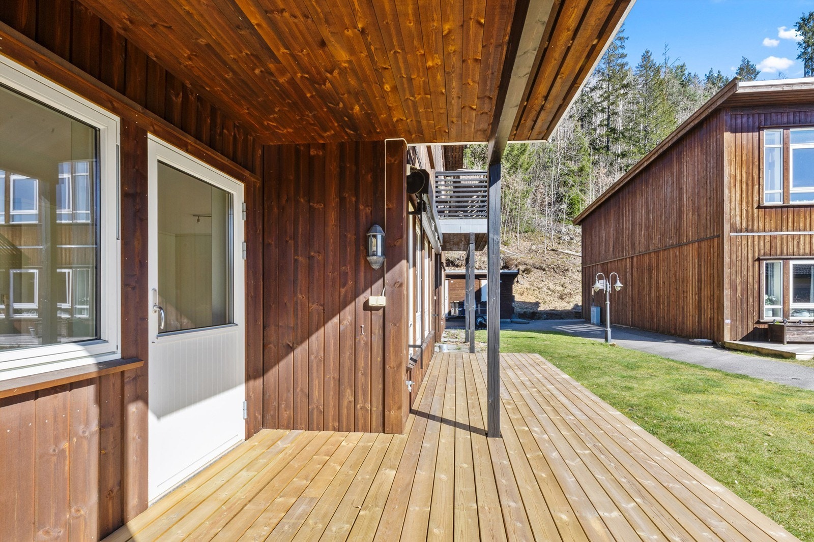 Terrasse med lite innhuk under tak, som gir et koselig uteområde med skjerming for vær og vind. Galleribilde