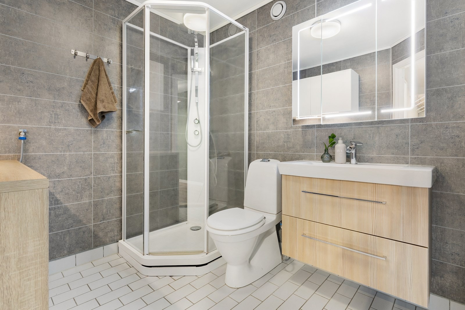 Baderom med hovedkonstruksjon fra byggeår. Gulvet er flislagt og har elektriske varmekabler, og veggene er belagt med baderomsplater. Galleribilde