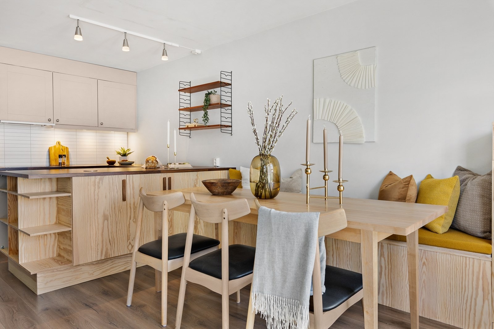 Halvøyen deler rommet naturlig inn i soner, selv om stue og kjøkken er i åpen løsning. I tilknytning til øyen er det laget en plassbygget sittebenk med oppbevaring under. Galleribilde