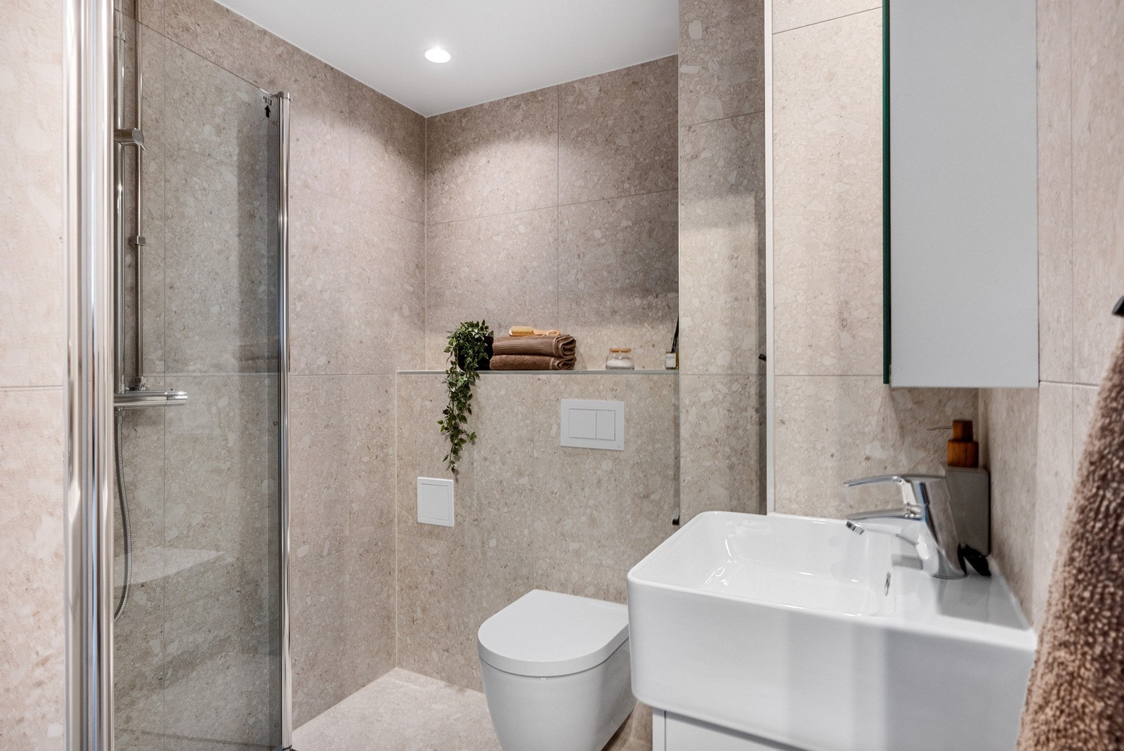 Delikat, flislagt baderom med downlights i himling og varme i gulv. Italienske Terrazzo-fliser av høy kvalitet. Galleribilde