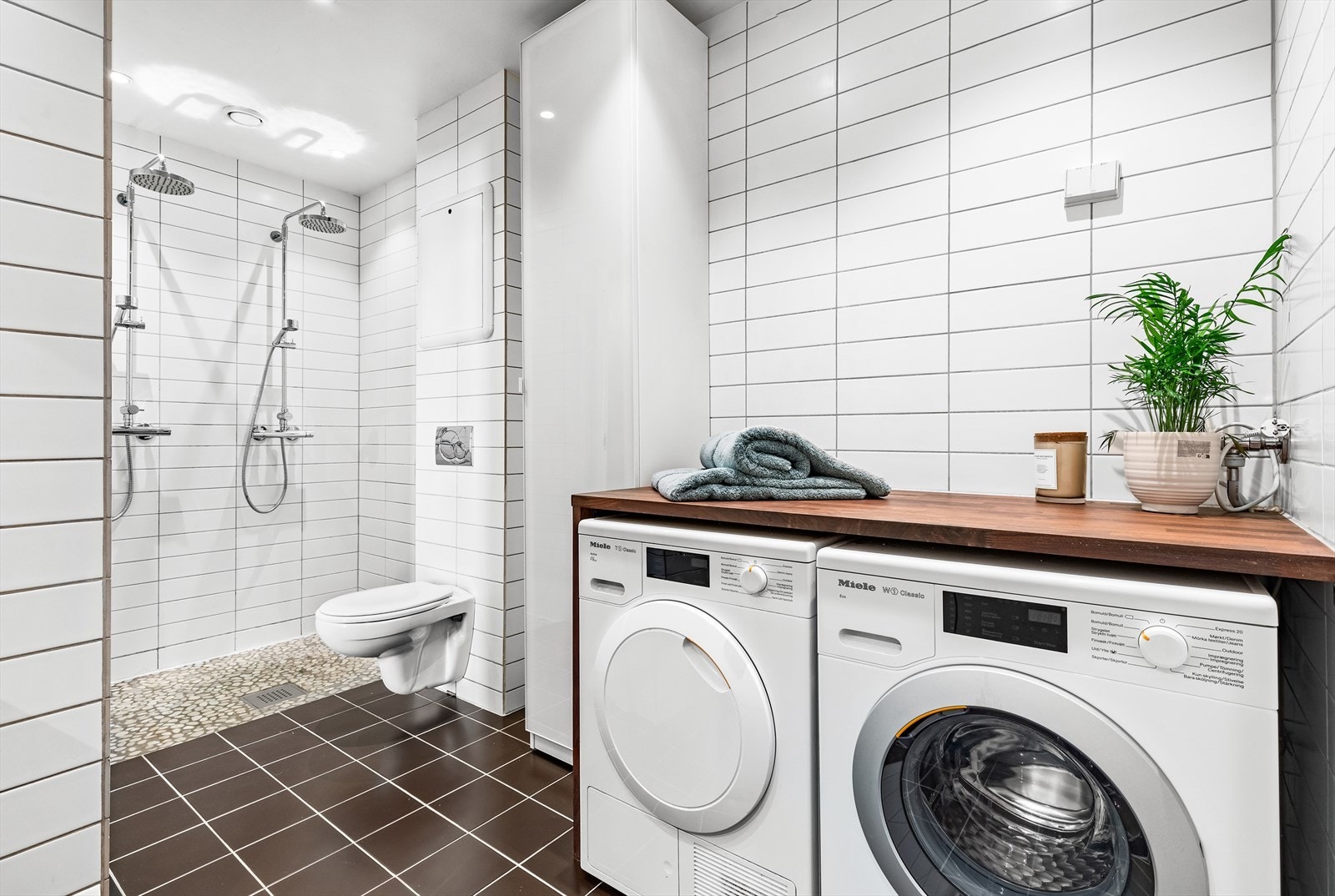 Det er opplegg for vaskemaskin og tørketrommel under benkeplate. God plass til lagring i høyskap og f.eks stellebord på benken. Galleribilde