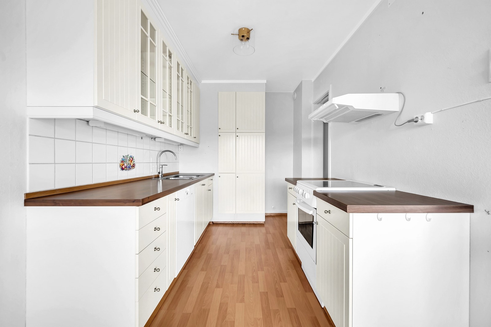 Over kjøkkenbenken er det pent flislagt med praktisk benkeskapsbelysning og stikkontakter. Galleribilde