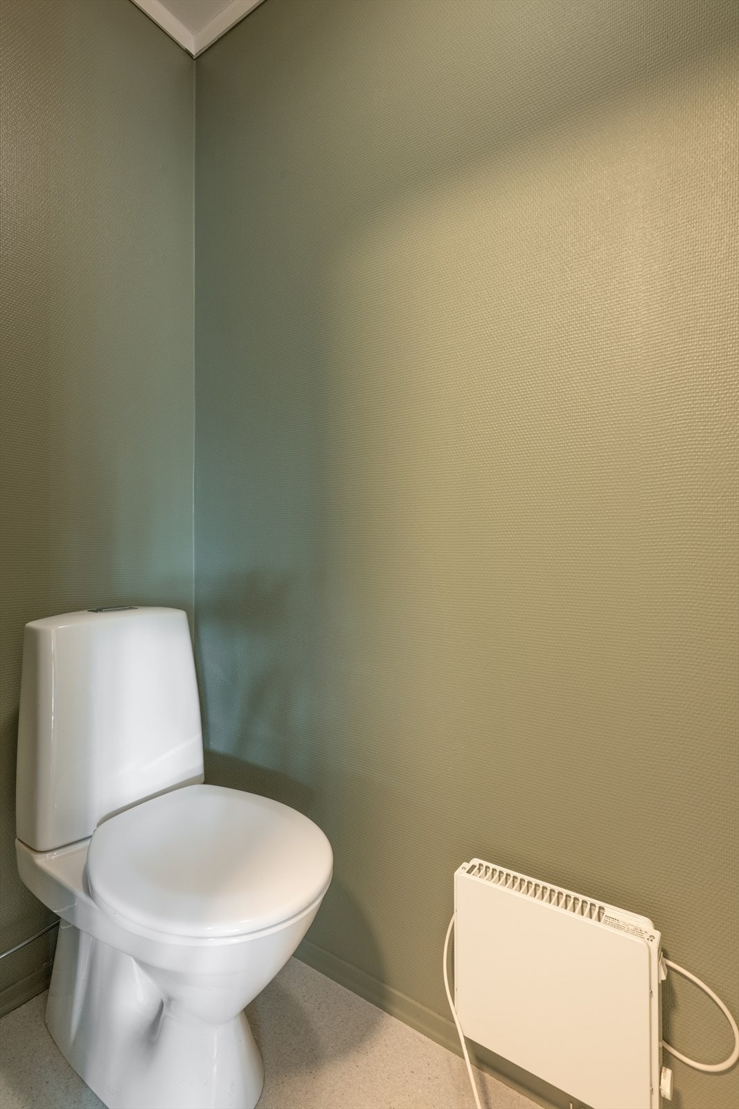 Toalettrommet er innredet med toalett og opplegg for vaskemaskin. Galleribilde