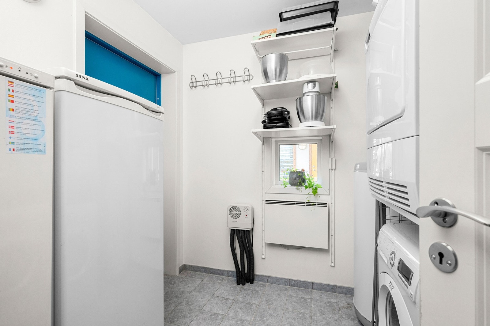 Bod som er innredet som vaskerom med flis på gulv. Rommet har egen inngang fra utsiden. Galleribilde