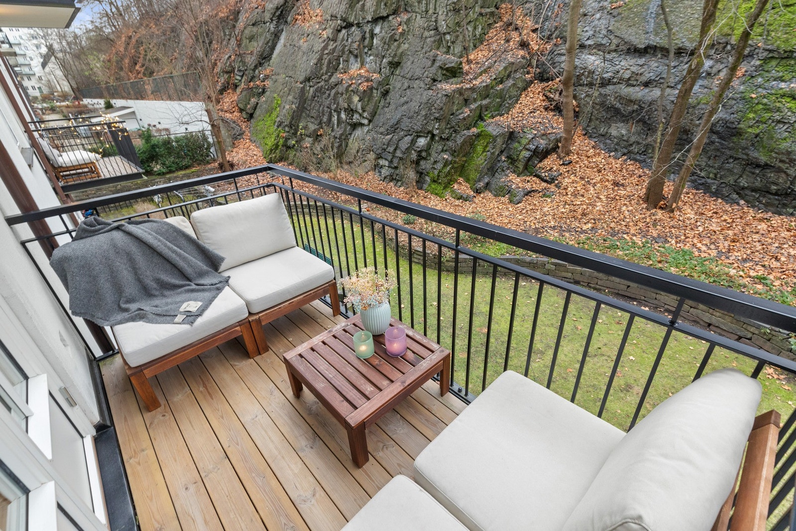 Balkong vender inn mot skjermet og grønn bakgård. Galleribilde