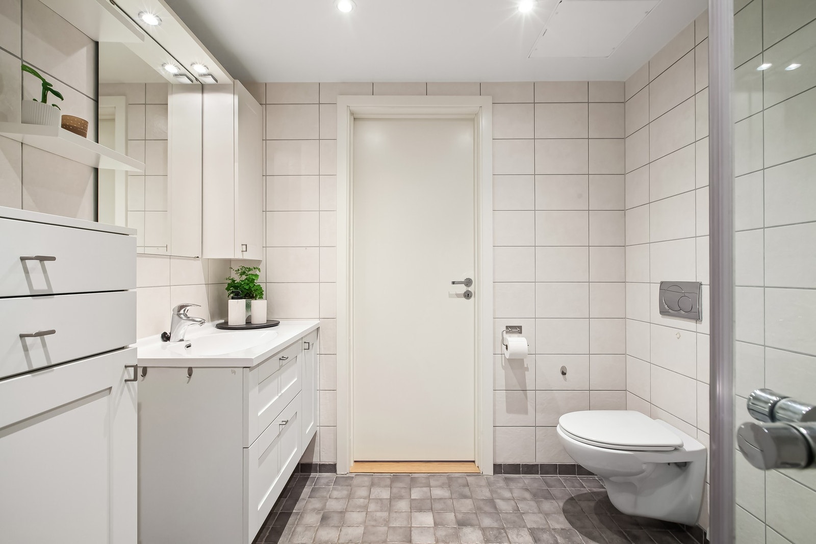 Praktiske løsninger som plass til vaskemaskin og godt med benkplass over, gjør dette badet svært anvendelig i hverdagen. Galleribilde
