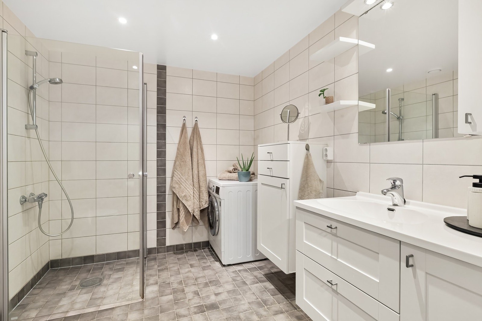 Badet fremstår som lyst, innbydende og svært funksjonelt - innredet i en moderne og tidløs stil. Galleribilde