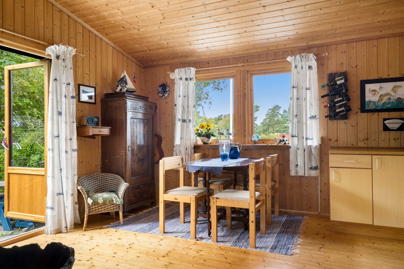 Stuen har furugulv, paneloverflater og godt med dagslys fra vindusflater på to sider. Galleribilde