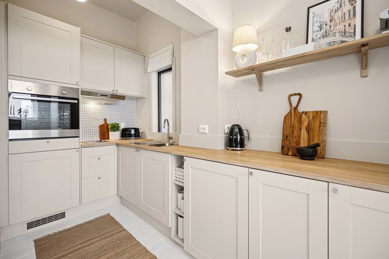 Lyst og delikat kjøkken fra IKEA med malte profilerte fronter og heltre benkeplate. Galleribilde