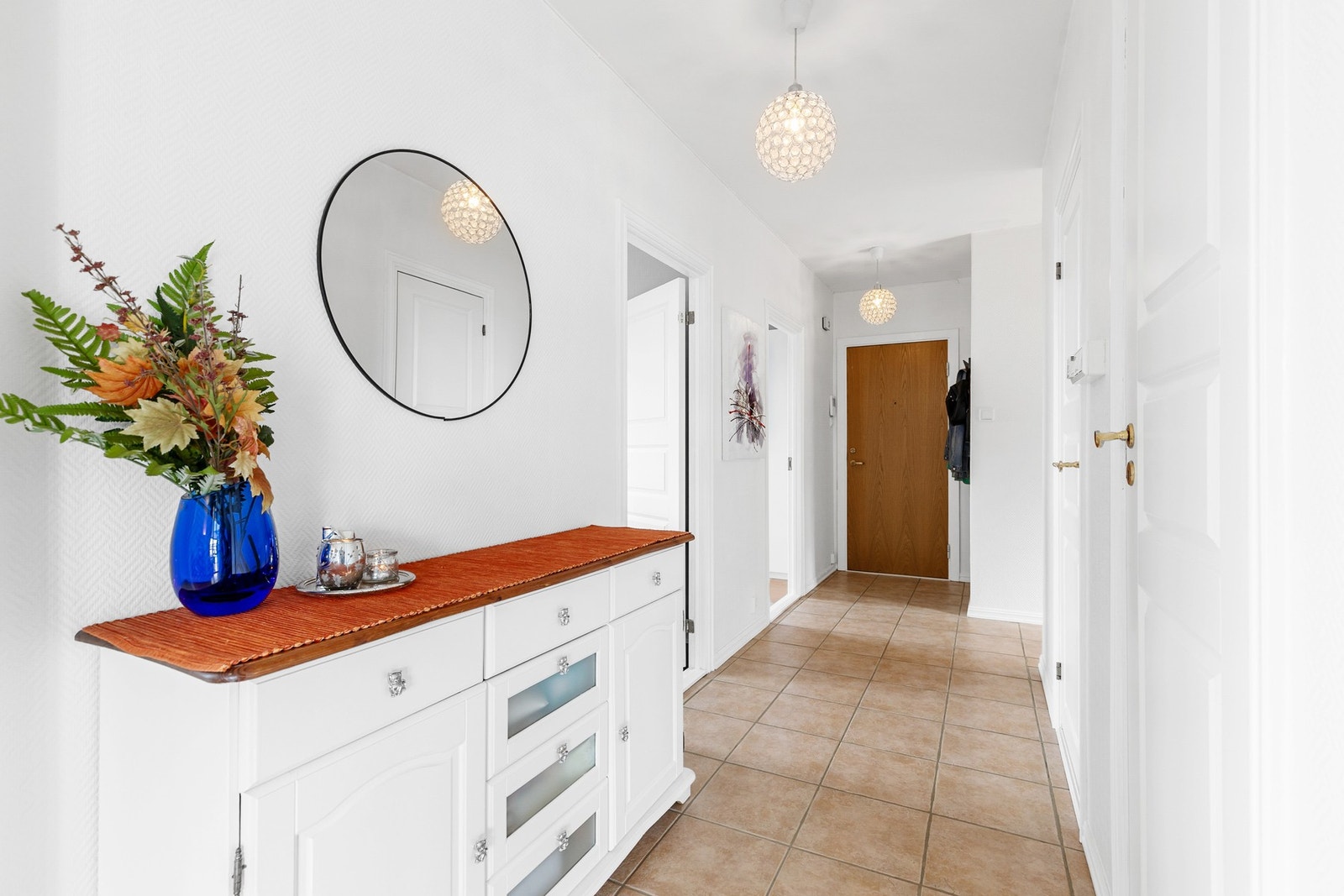 Romslig entré med fliser på gulv og callinganlegg Galleribilde