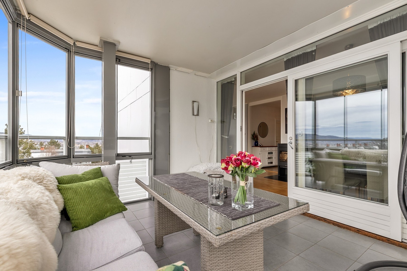 Balkongen har fliser på gulv og vegger av glass og metall Galleribilde