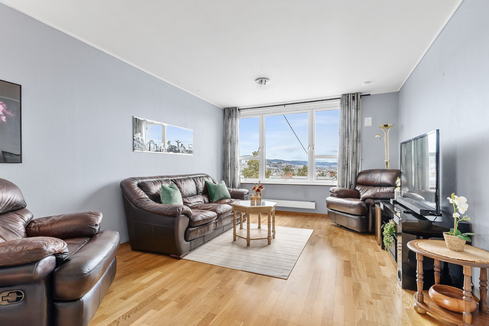 Rommet har store vindusflater som slipper inn godt med naturlig lys Galleribilde