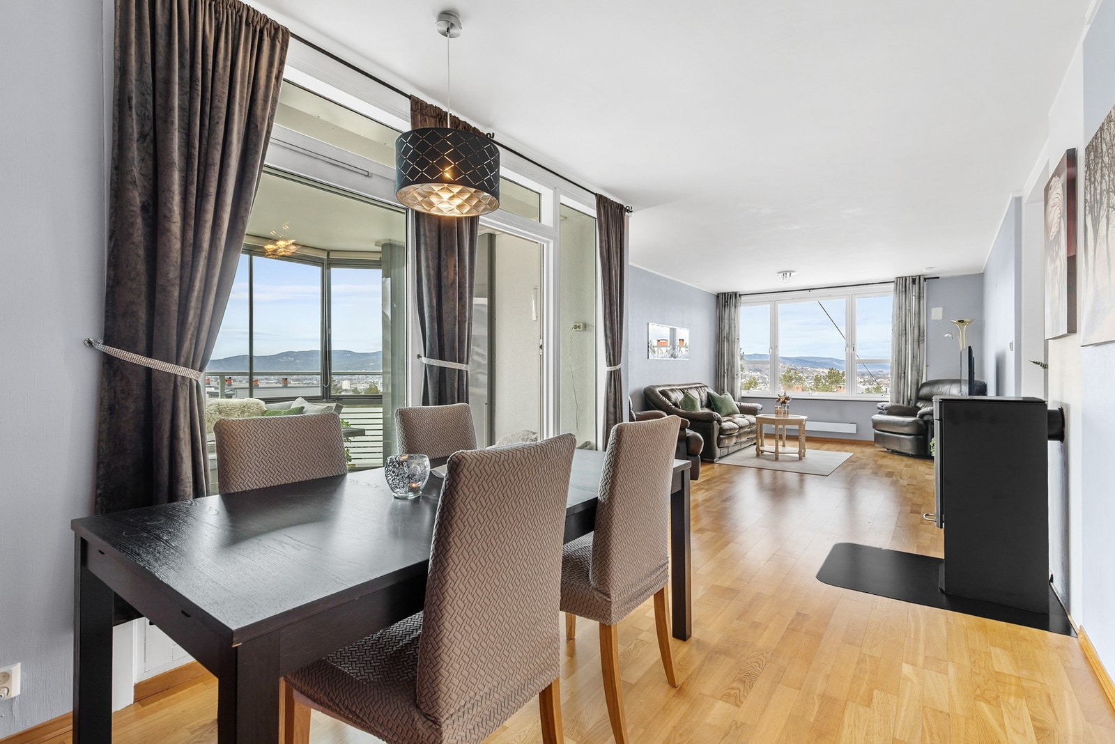 Romslig stue med parkett på gulv og malt tapet på vegger Galleribilde