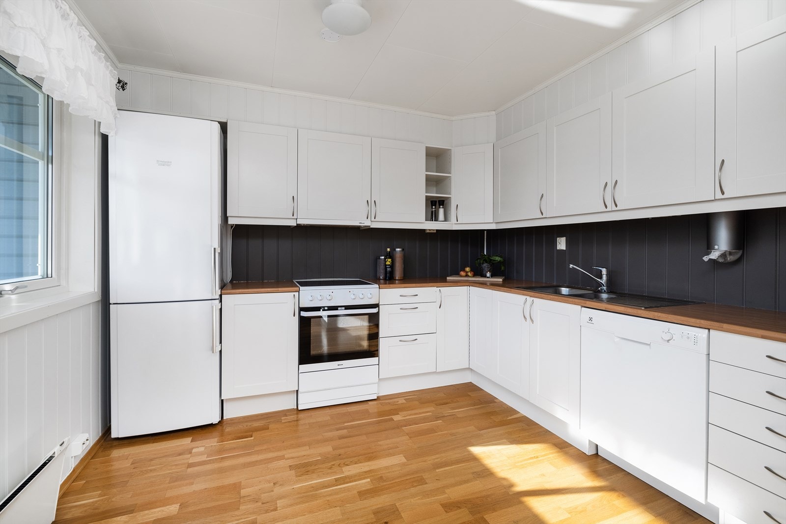 Kjøkkenet er innredet i en lys og klassisk stil med profilerte fronter og laminat benkeplate, samt avsatt plass til kjøl/fryseskap, komfyr og oppvaskmaskin. Galleribilde