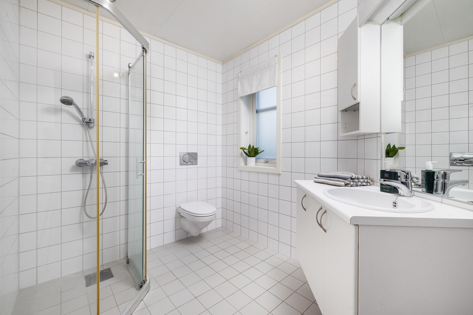 Boligen byr på to lyse, flislagte bad med elektrisk gulvvarme, hvor badet i 1. etasje har innredning med nedfelt servant, veggmontert toalett og dusjvegger/hjørne, og har mekanisk avtrekk. Galleribilde