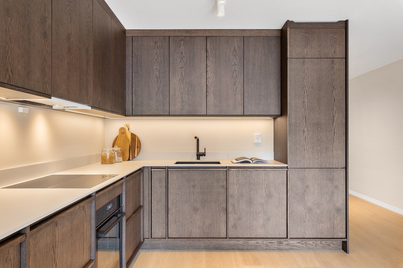 Kjøkkenet har pene fronter i mørk eik og benkeplate av kompaktlaminat Galleribilde