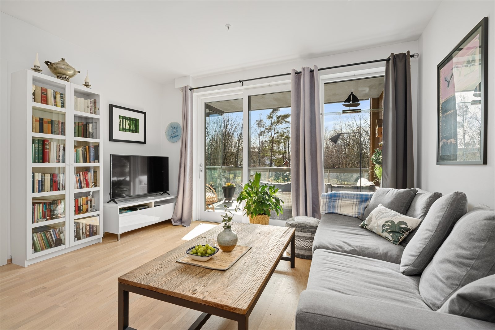 Store vindusflater sørger for rikelig med naturlig dagslys inn i den åpne stue/kjøkkenløsningen. Legg merke til den flotte glasshyllen nåværende eier har fått satt inn i vinduet i stuen. Galleribilde