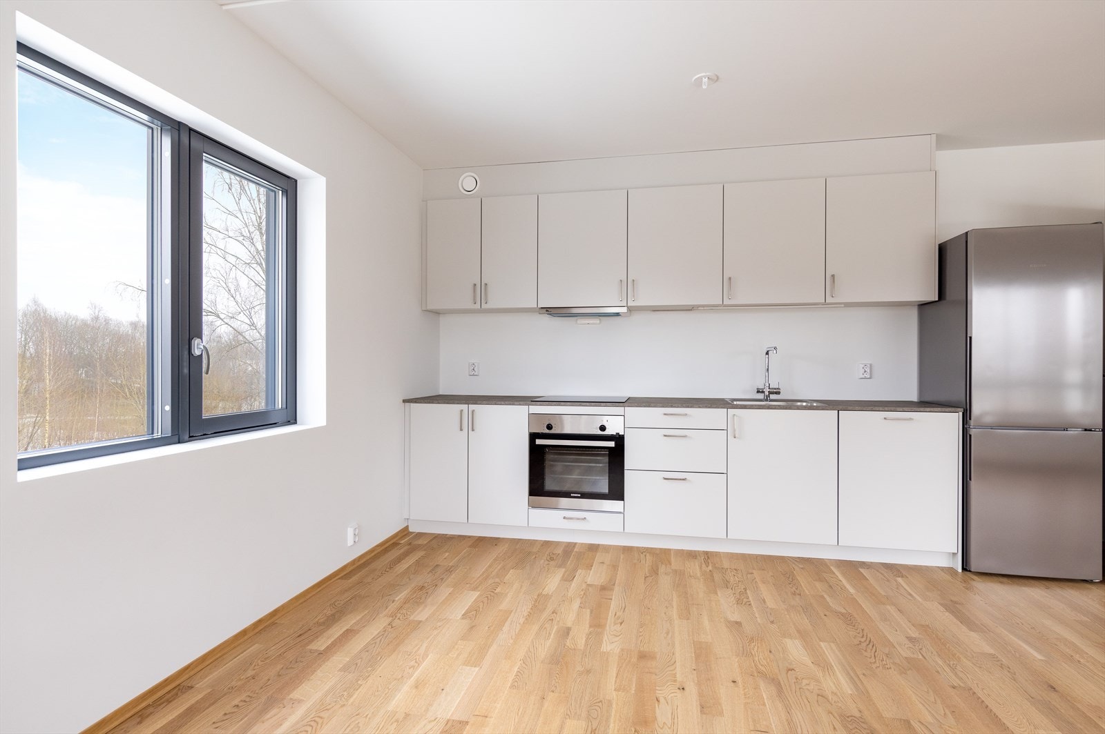 Kjøkken fra Drømmekjøkkenet leveres med integrerte hvitevarer som oppvaskmaskin, induksjonstopp, stekeovn og frittstående kjøl/fryseskap Galleribilde