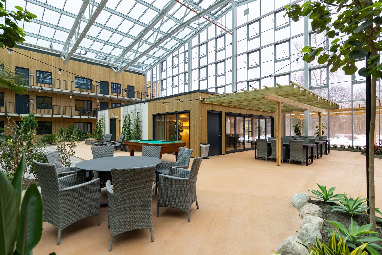 Flere sittegrupper og sosiale soner i hagen og ved felleshuset. Galleribilde