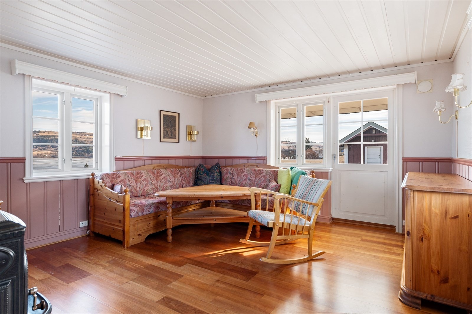 Stue i kårbolig med utgang til overbygget terrasse. Vedovn i stuen. Galleribilde