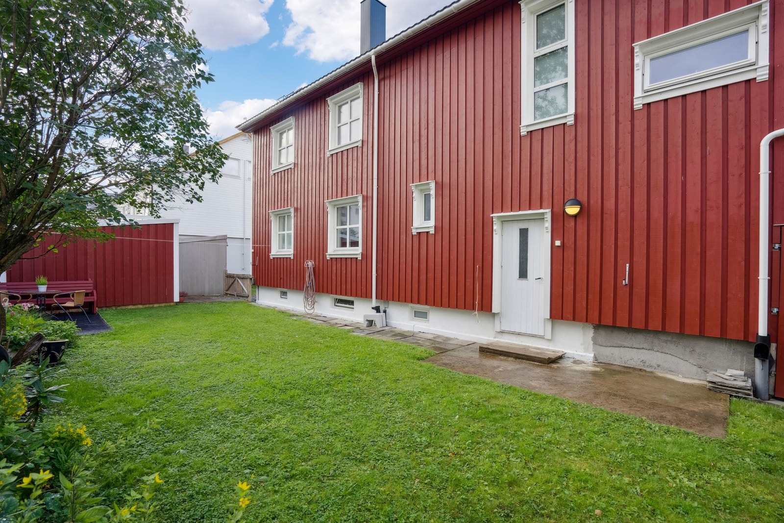 Hage på baksiden av boligen. Her ses også uthus og eldre garasje. Galleribilde